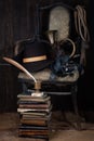 Adventure fiction - Vintage old broken wooden chair with hat, sword, bugle, books and fountain pen with inkpot Royalty Free Stock Photo