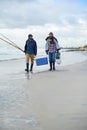 Adventure, fishing and men walking on beach together with cooler, tackle box and holiday bonding. Ocean, fisherman and Royalty Free Stock Photo