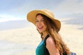 Adventure girl with backpack and straw hat looking to the camera. Young woman exploring Canarian Coast