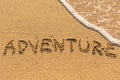 Adventure - inscription by hand on beach sand Royalty Free Stock Photo