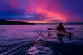 Adventure Man on a Sea Kayak is kayaking at Sunset Royalty Free Stock Photo