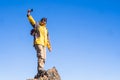 Adventure man standing outdoor on the top of a mountain with blue sky in background - concept of travel and trekking or hiking Royalty Free Stock Photo