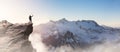 Adventure Man on top of Rocky Mountain Cliff. Aerial Canadian Mountain landscape from British Columbia, Canada. Royalty Free Stock Photo