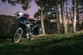 Adventure motorcycle in night forest, Motorcyclist gear, A motorbike driver looks, concept of active lifestyle, enduro travel road