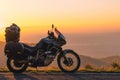 Adventure motorcycle, silhouette touristic motorbike. the mountain peaks in the dark colors of the sunset. Copy space. Concept of