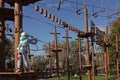 teenage girl on a difficult obstacle course is preparing to overcome. Adventure park obstacle course Royalty Free Stock Photo