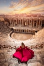 Adventure photo tourist woman in red dress on background Amphitheater in Hierapolis ancient city Pamukkale Turkey