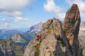 Adventure photographer looking around from a small ridge up on via ferrata Delle Trincee, in Dolomites mountains, Italy. Royalty Free Stock Photo