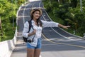 Adventure recreation travel concept. Young woman wearing hat carrying backpack with camera use her hand hitchhiking for help Royalty Free Stock Photo