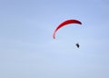 Adventure sport paragliding on a summer day with clear blue sky.