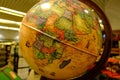 Adventure stories background. Old globe on map background. Selective focus.