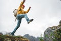 Adventure tourist jumping on rocks over cliff