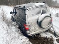 Adventure travel concept background. A 4x4 SUV stuck in mud and snow. Problems of car ownership in winter. Royalty Free Stock Photo