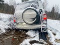 Adventure travel concept background. A 4x4 SUV stuck in mud and snow. Problems of car ownership in winter. Royalty Free Stock Photo