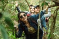 Adventure; travel; tourism; hike and people concept - group of smiling friends walking with backpacks in woods Royalty Free Stock Photo