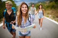 Adventure, travel, tourism and people concept - group of smiling friends with backpacks and map