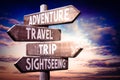 Adventure, travel, trip, sightseeing - wooden signpost, roadsign with four arrows Royalty Free Stock Photo