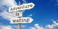 Adventure is waiting - wooden signpost with three arrows Royalty Free Stock Photo