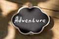 Adventure waiting for you concept small sign with Adventure inscription outdoors, wooden background