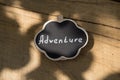 Adventure waiting for you concept small sign with Adventure inscription outdoors, wooden background