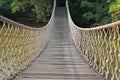 Adventure wooden rope suspension bridge crossing river