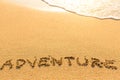 Adventure - word drawn on the sand beach