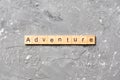 Adventure word written on wood block. adventure text on cement table for your desing, concept