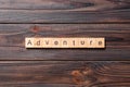 Adventure word written on wood block. adventure text on cement table for your desing, concept