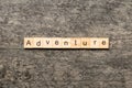 adventure word written on wood block. adventure text on cement table for your desing, concept