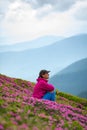 Adventurer female relaxing among flowering rhododendrons Royalty Free Stock Photo