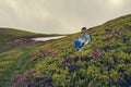 Adventurer female is relaxing on the green mountain slope Royalty Free Stock Photo