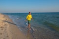 Adventurer, laughing, is walking along the surf line Royalty Free Stock Photo