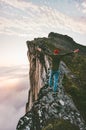 Adventurer man on the edge mountain ridge above clouds Royalty Free Stock Photo