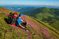 Adventurer relaxing among flowering pink rhododendrons Royalty Free Stock Photo