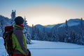 Adventurer observes the sunrise on the horizon