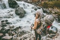 Adventurer travel woman hiking with backpack at river in mountains