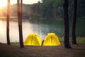 Adventures camping tourism and tent under the pine forest in sunset Royalty Free Stock Photo