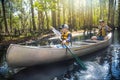 Adventuresome Father and son canoeing together on a beautiful river in a thick forest Royalty Free Stock Photo