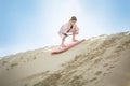 An adventuresome Little Girl boarding down the Sand Dunes Royalty Free Stock Photo