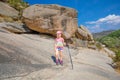 Adventuress little child with trekking sticks hiling in rocky mountain Royalty Free Stock Photo