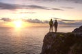 Adventurous couple holding hands and standing on a rocky cliff Royalty Free Stock Photo