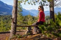 Adventurous Female Hiker is sitting on a bench and enjoying the beautiful Canadian Mountain Landscape