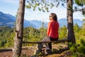 Adventurous Female Hiker is sitting on a bench and enjoying the beautiful Canadian Mountain Landscape