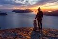 Adventurous Girl Hiking on top of a Mountain with a dog