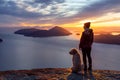 Adventurous Girl Hiking on top of a Mountain with a dog