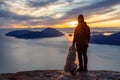 Adventurous Girl Hiking on top of a Mountain with a dog