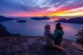 Adventurous Girl Hiking on top of a Mountain with a dog