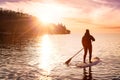 Adventurous girl on a paddle board is paddeling in the Pacific West Coast Ocean Royalty Free Stock Photo