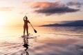 Adventurous girl on a paddle board is paddeling in the Pacific West Coast Ocean Royalty Free Stock Photo