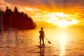 Adventurous girl on a paddle board is paddeling in the Pacific West Coast Ocean Royalty Free Stock Photo